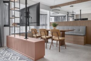 Mari Bamont_Integração entre sala e área de jantar com soluções multifuncionais_rack giratório com TV marcenaria contínua e estante como divisória de ambientes. Fotos Carin