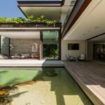 Lago na área externa protagoniza projeto residencial que une paisagismo com arquitetura moderna